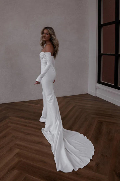 Unique off the shoulder long sleeved Bohemian style satin wedding dress paired with court train