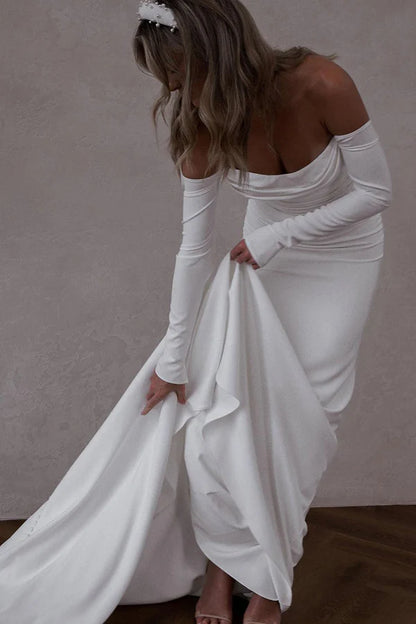 Unique off the shoulder long sleeved Bohemian style satin wedding dress paired with court train